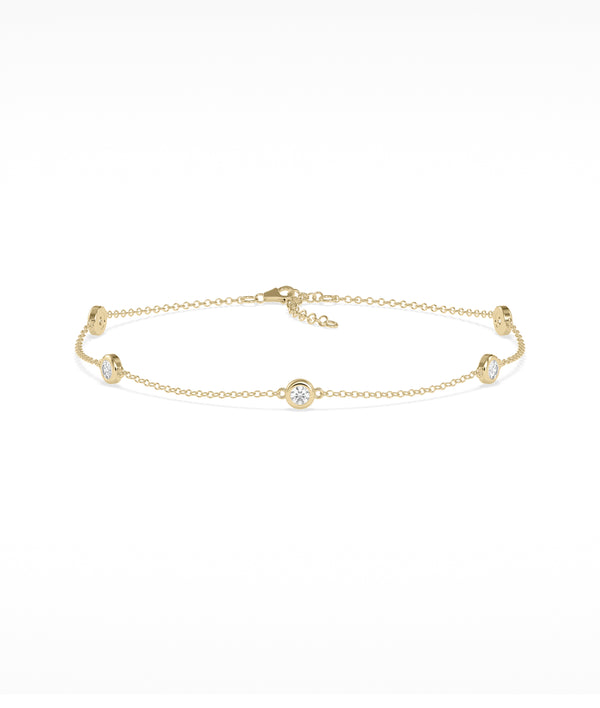 Bezel set station bracelet in 14K yellow gold with diamond gemstones