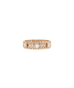 Rose gold chevron ring featuring bezel-set diamond stations and modern pattern