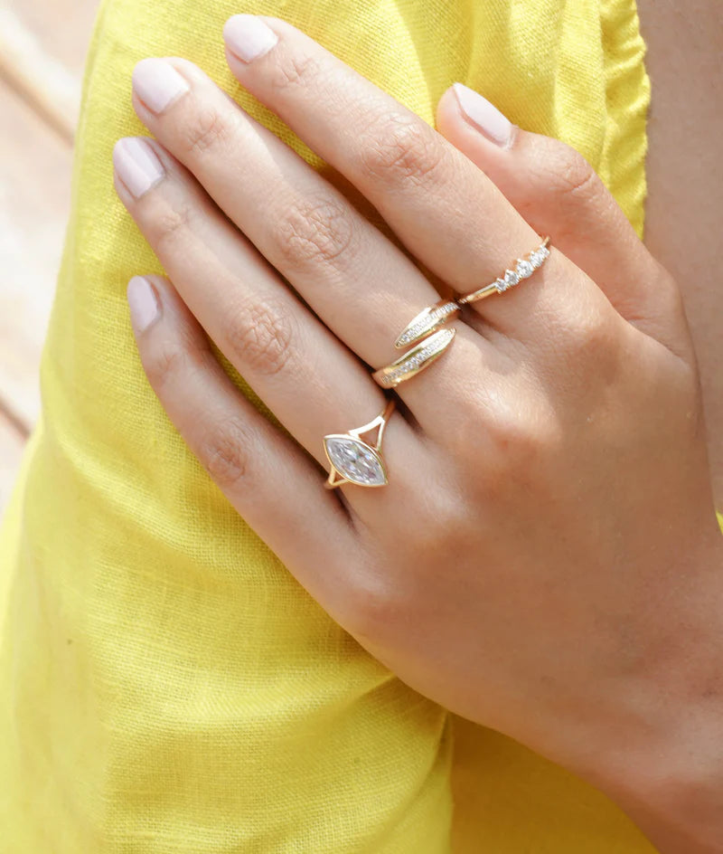 Model wearing bezel marquise lab diamond solitaire ring in yellow gold