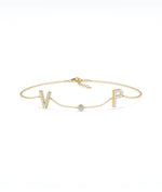 Custom initials solitaire bracelet in 14K yellow gold with aquamarine gemstone