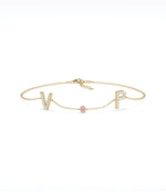 Custom initials solitaire bracelet in yellow gold with pink sapphire gemstone