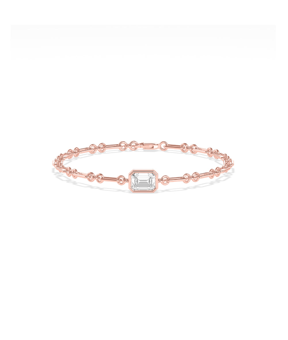 Rose gold chain bracelet featuring a bezel-set emerald-cut diamond solitaire centerpiece