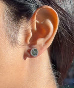 Model wearing fluted diamond round stud earrings in yellow gold