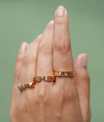 Model wearing personalized gold initial band ring in yellow gold