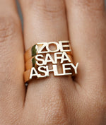 Model wearing three personalized gold initial band rings on finger