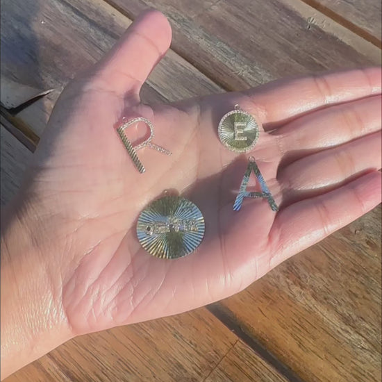 Fluted diamond initial charm styled as pendant showing statement-making size