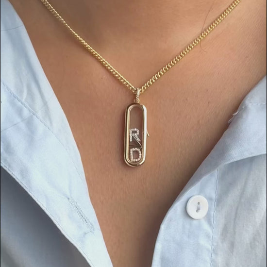 Capsule glass locket charm styled with layered chains and mixed pendant shapes