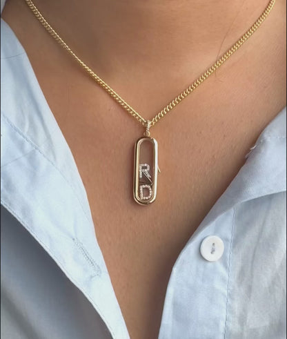 Capsule glass locket charm styled with layered chains and mixed pendant shapes