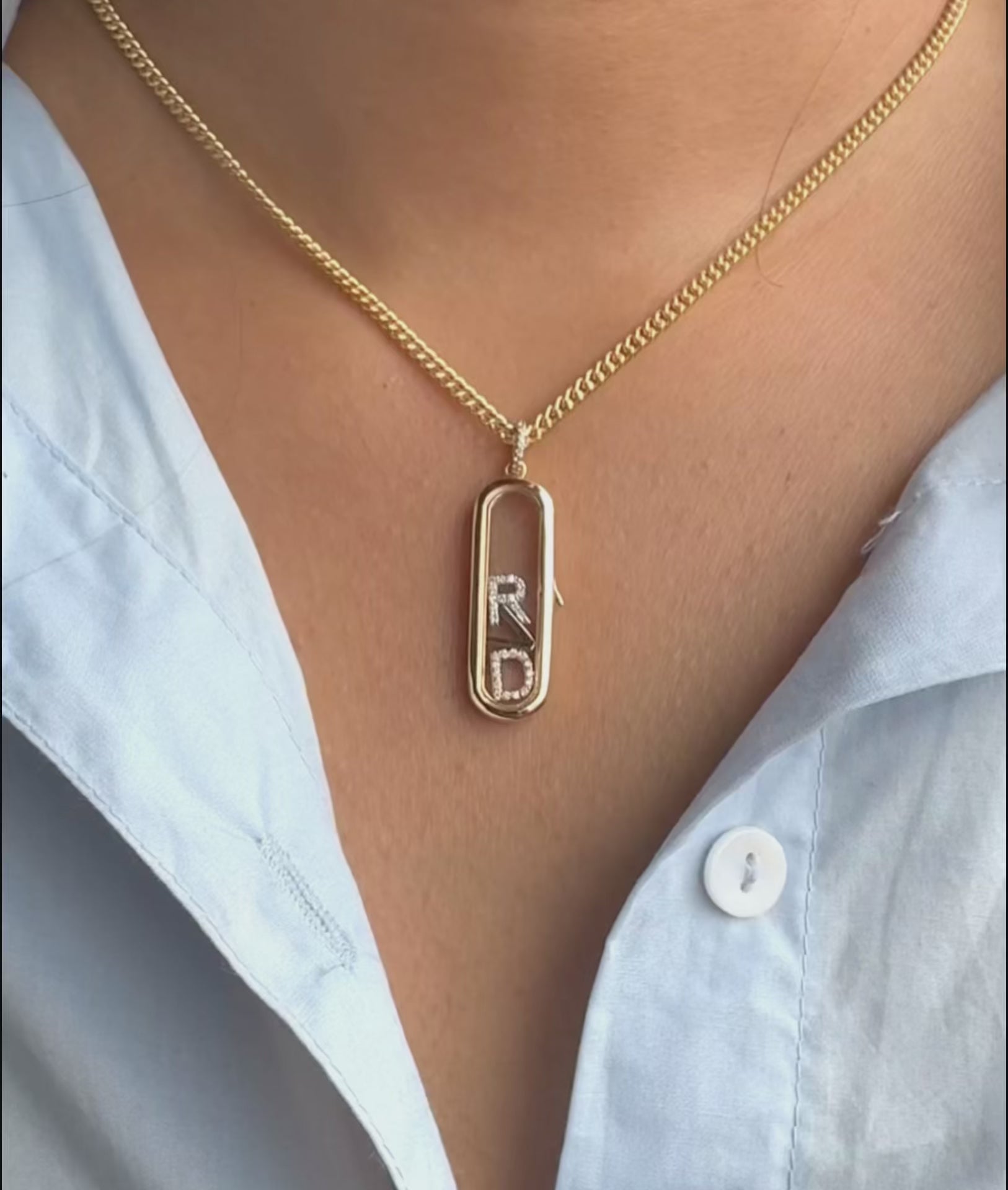 Capsule glass locket charm styled with layered chains and mixed pendant shapes