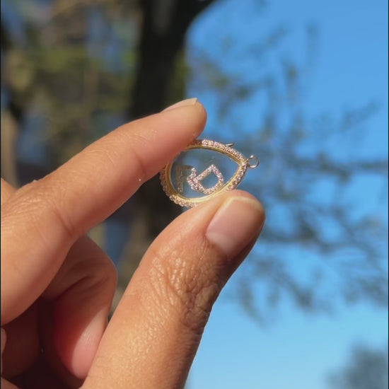 Diamond pear shape glass locket charm beautifully displayed on upscale jewelry presentation