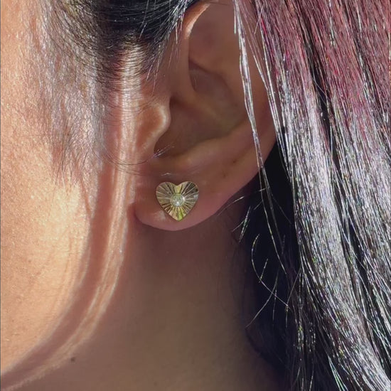 Fluted heart stud earrings pair displayed on elegant romantic jewelry presentation