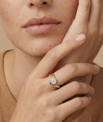 Model wearing pear lab diamond solitaire bypass wave ring in yellow gold